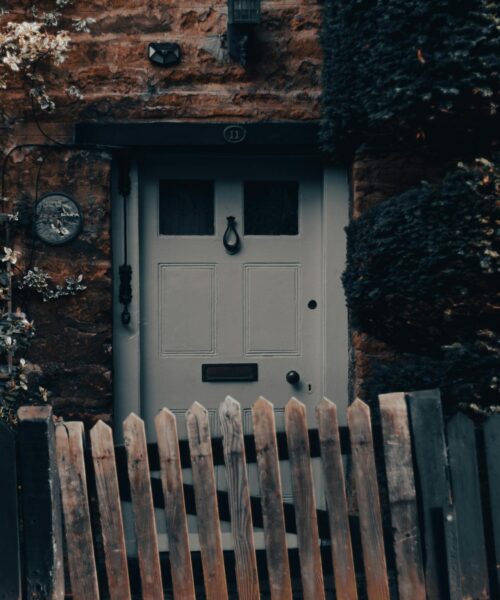 white-door-behind-old-fence